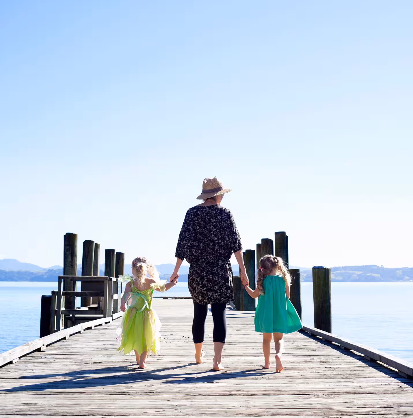 Middle aged woman and daughters walking on pier